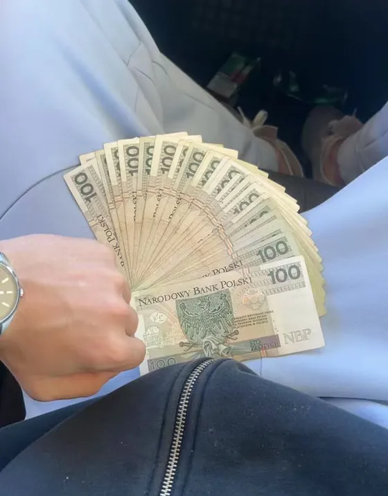 Plik banknotów stuzłotowych trzymany w dłoni